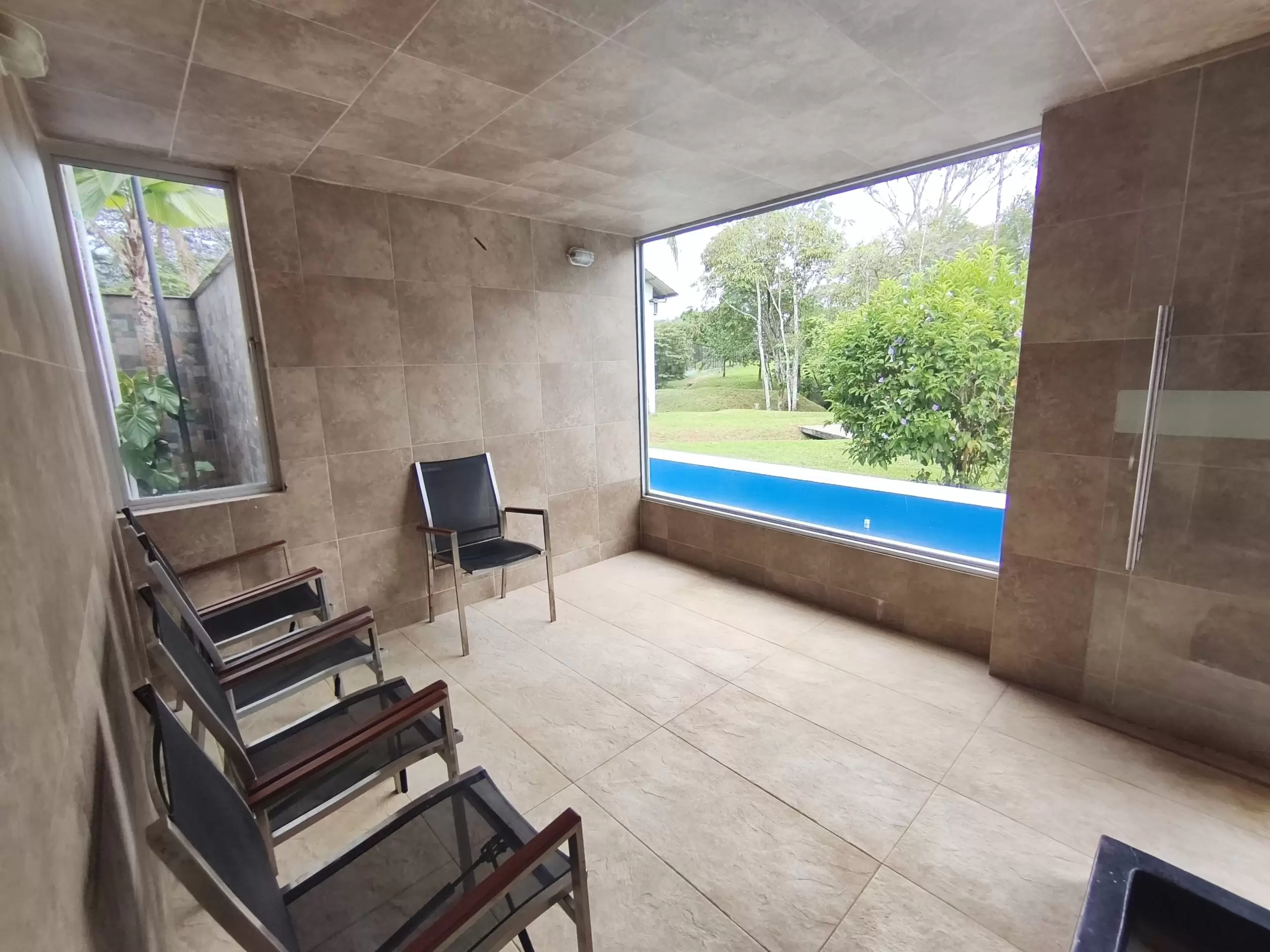 Área de turco del condominio campestre, equipada con sillas y revestida en cerámica.